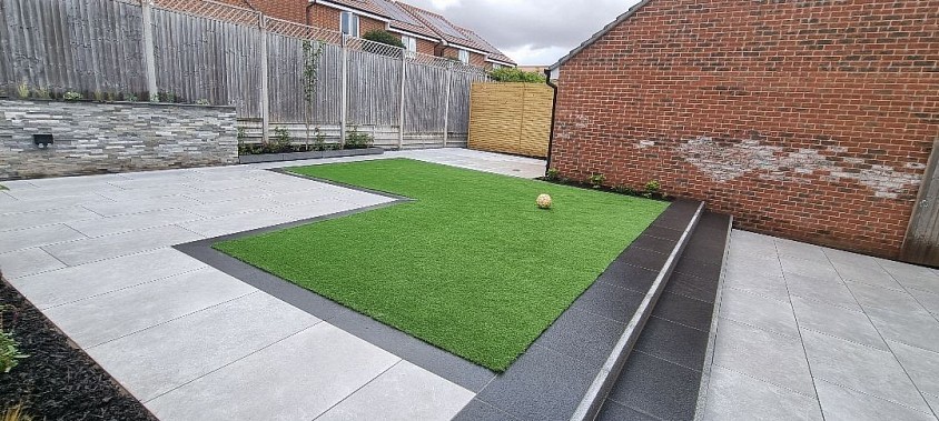 Landscaping project included full excavation work and installation of porcelain paving, granite steps, risers and edging the artificial lawn.